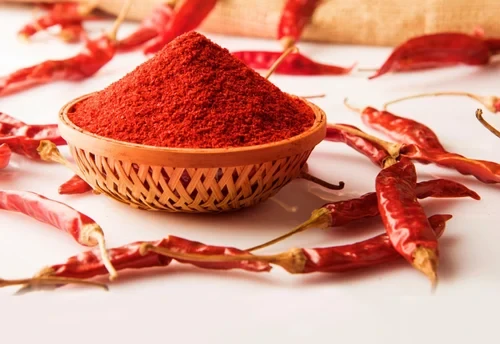 Guntur chilli powder in a woven basket with dried red chillies